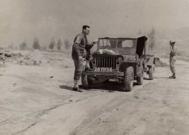 A person standing next to a military vehicle

Description automatically generated with low confidence