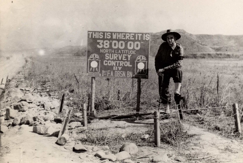 A person standing next to a sign

Description automatically generated